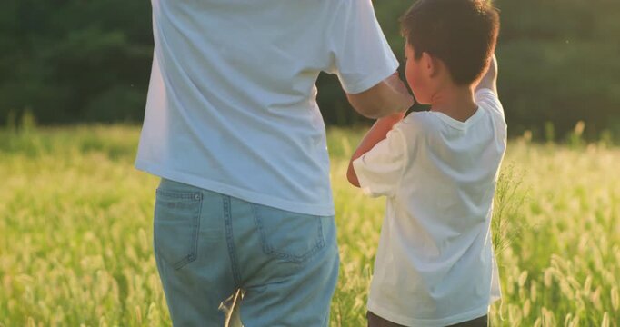 Chinese mother and son playing with foxtail grass outdoors