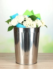 Flowers and papers in a trash can