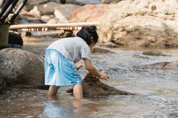 Child Playing in Stream, Exploring Nature, Enjoying Outdoor Activities, Engaging with Water, Summer Fun, Discovering Wildlife, Creating Memories in Nature