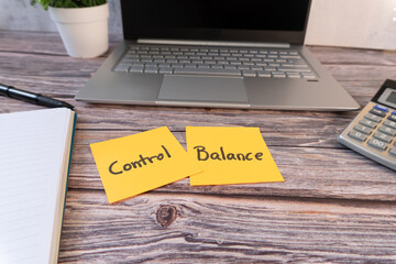 Work desk with notebook, laptop, calculator, and a pair of sticky notes with the words 