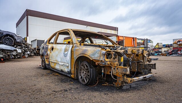 Wrecked Car Remains at Junkyard Automotive Graveyard Scene Featuring Burnt Vehicle Parts and Scrap Metal Aftermath Environment - Powered by Adobe