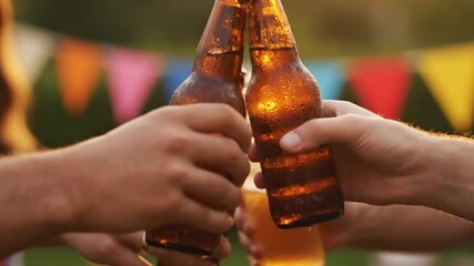 A vibrant, slow-motion shot of friends laughing and clinking beer bottles at a backyard BBQ party, a fun summer celebration concept.