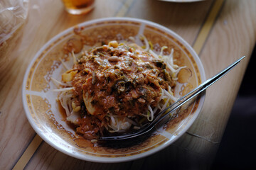 Toge Goreng from Bogor served on a traditional plate, featuring bean sprouts, noodles, and tauco sauce in a rustic warung setting with authentic local ambiance.