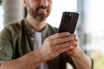 Close up of man using mobile phone, browsing internet, checking email, social media, mobile app