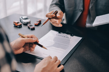 Car salesman gave the keys to the customers who signed the purchase contract legally, Successful completion of car sales, Purchase contract and key delivery.