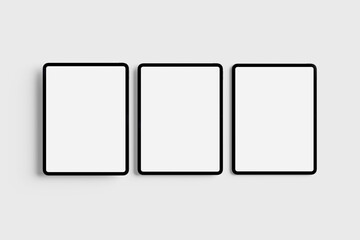 Three Modern Digital Tablets with Blank White Screens on a Light Background
