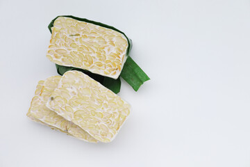 Fresh, raw tempeh wrapped in a banana leaf, a traditional way of fermenting this healthy Indonesian...