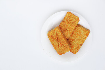 golden fried tempeh on a white plate, highlighting Indonesia’s iconic plant-based protein with clean styling and cultural depth