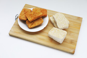 Golden-brown fried tempeh slices, cooked without any coating, showcasing their natural texture. A delicious, high-protein Indonesian classic.