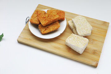 Golden-brown fried tempeh slices, cooked without any coating, showcasing their natural texture. A delicious, high-protein Indonesian classic.