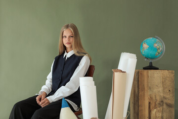 Young student girl in formal school uniform sitting near globe and study materials, symbolizing education, knowledge, and learning