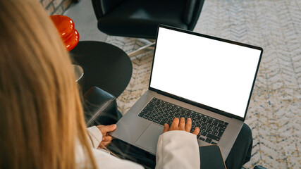 Close-up of woman working on laptop with smartphone nearby, modern freelance lifestyle and technology concept in loft interior