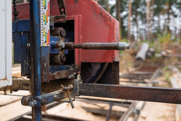 Close-up of machine for sawing pine logs at sawmill