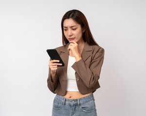 Pretty young asian woman using smartphone feeling upset confused bad depressed emotional standing on isolated white background. Holding cell phone. Thinking and stressed