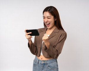 Naklejka premium Pretty young asian woman using cellphone standing on isolated white background. Happy Excited Beautiful young asian shopping online payment with mobile phone. Playing game on smartphone