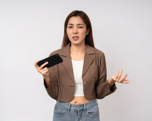 Fototapeta premium Pretty young asian woman using smartphone feeling upset confused bad depressed emotional standing on isolated white background. Holding cell phone. Thinking and stressed