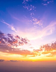 Naklejka premium Vibrant sunset hues paint the sky with colorful clouds and hazy horizon