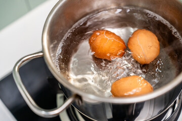Boiled eggs in a pot. Chicken eggs boiling in saucepan on gas stove