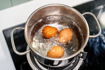 Boiled eggs in a pot. Chicken eggs boiling in saucepan on gas stove