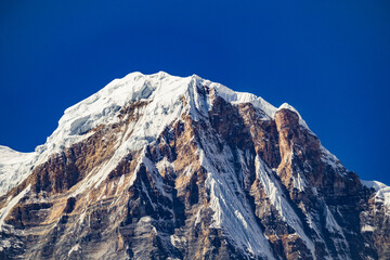 Majestic Mount Annapurna South peak against blue sky viewed from Annapurna Base Camp trekking route in Nepal Himalaya