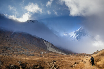 Annapurna Base Camp Trail with a lone trekker at sunrise with Mist and Mountain Peaks, Nepal Himalayas