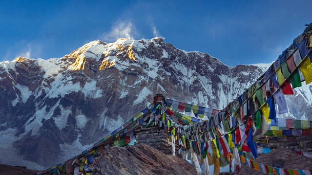 Mount Annapurna peak at sunrise. Buddhist Prayer Flags Against Himalayan Mountain Peaks at Sunrise at Annapurna Base Camp, Nepal