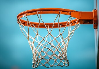 Close up of an orange basketball hoop with a white net against a blue sky image
