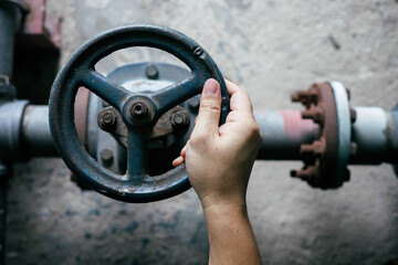 Top view of hand holding circular water valve to turn water on or off