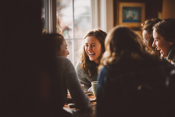Friends laughing together at dinner table