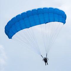 Photo of Parachutist Soaring Through the Blue Sky with a Blue Parachute