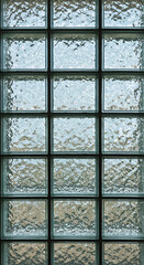 Frosted glass panel in a grid pattern with square panes, showing a blurred outdoor scene. Architectural detail with a neutral tone.