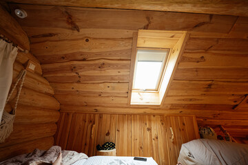 Obraz na płótnie Canvas Cozy wooden attic with sunlight entering through a skylight window