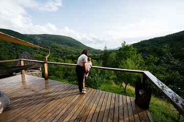 Fototapeta premium Mother and child enjoying a scenic view from a wooden deck in nature