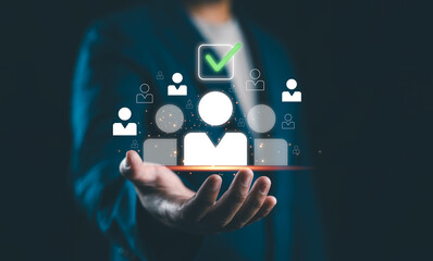 Human Resources Recruitment and Hiring Concept. Businessman holds virtual icons representing potential candidates, with one icon highlighted and a check mark, illustrating HR recruitment and hiring.