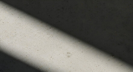 A close-up view of a light gray concrete surface displays textured specks and a diagonal shadow. Suitable for architectural or construction-related stock use.