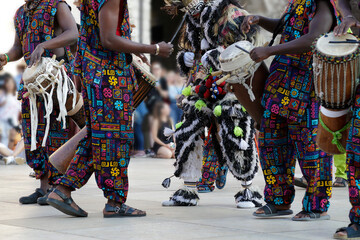 Men playing playing drums and wearing one of the traditional costume from Dakar, Senegal