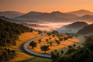 Winding road through golden hills at sunrise, misty valley below. Mountain backdrop