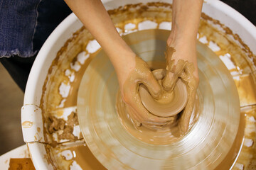 potter's wheel and girl's hands sculpting clay	