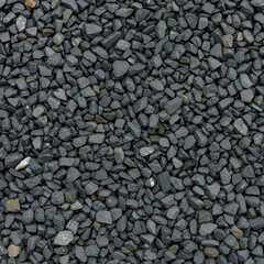 Dark gray gravel covering a surface, close-up view of a gravel path. A uniform covering of small, irregular, dark gray stones. General construction material. outdoor use.