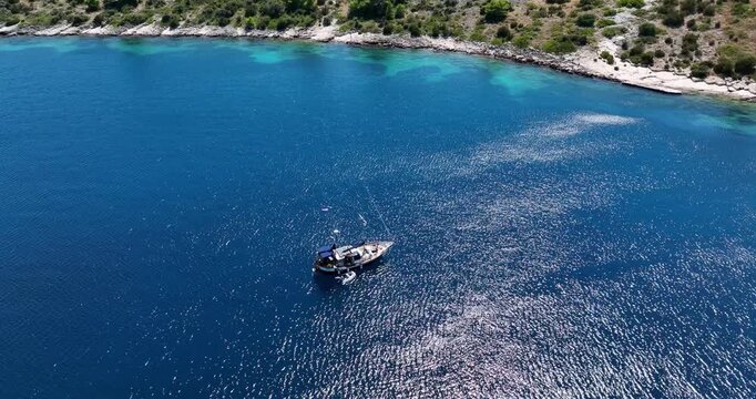 Lone sailboat glides through turquoise sea along Dugi Otok&rsquo;s rugged coastline