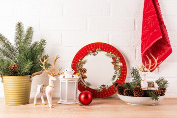 Obraz premium Beautiful New Year's kitchen background with decor elements in red traditional holiday colors. Kitchen wooden countertop decorated for Christmas