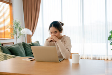 Thoughtful tired woman working on laptop computer looking on screen thinking solving problem at home office, serious woman search for inspiration make decision feel lack of ideas