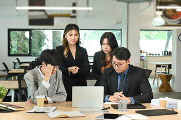 Business people having a serious meeting using laptop in the office