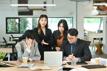 Business people having a serious meeting using laptop in the office
