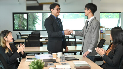 Businessman shaking hands with colleague after meeting in office