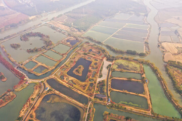 Aerial view of autumn foliage around a water-filled landscape