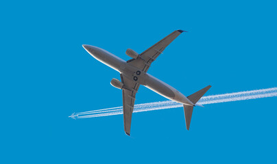 Trail of white smoke from the airplane on blue sky, airplane heavy traffic in the sky