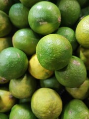 Fresh green limes stacked closely together at the market.
