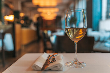 Glass of White Wine on Restaurant Table. Elegant Dining Atmosphere
