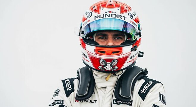A determined driver wears a vibrant motorsport helmet with a reflective visor and a white protective racing suit, looking directly forward.